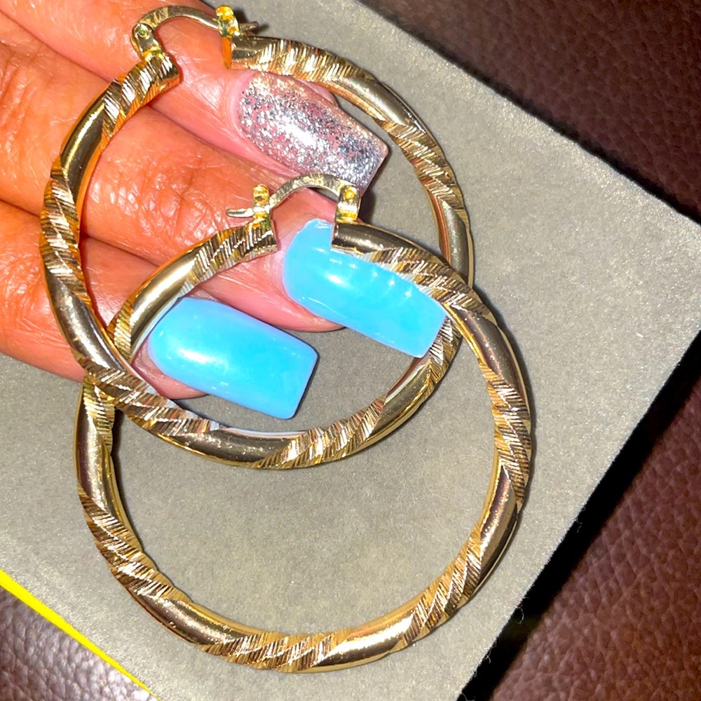 Gold plated used hoop earrings with carved in design.
